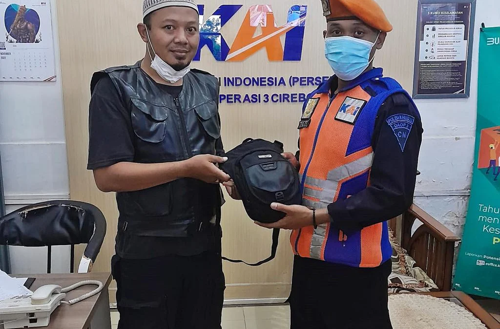 Petugas KAI memberikan barang yang tertinggal kepada pemiliknya. --FOTO: HUMAS PT KAI DAOPS 3 CIREBON