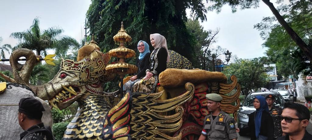 NAIK KERETA KENCANA: Wakil Walikota Cirebon Eti Herawati didampingi Madyawati mengendarai kereta kencana memasuki halaman Balaikota Cirebon saat Kirab Budaya Merah Putih. --FOTO: ABDULLAH/RADAR CIREBON