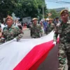 Bendera 500 meter dibentangkan pada acara Kirab Budaya Merah Putih di Kota Cirebon, Senin 6 Maret 2023. --FOTO: ABDULAH/RADAR CIREBON