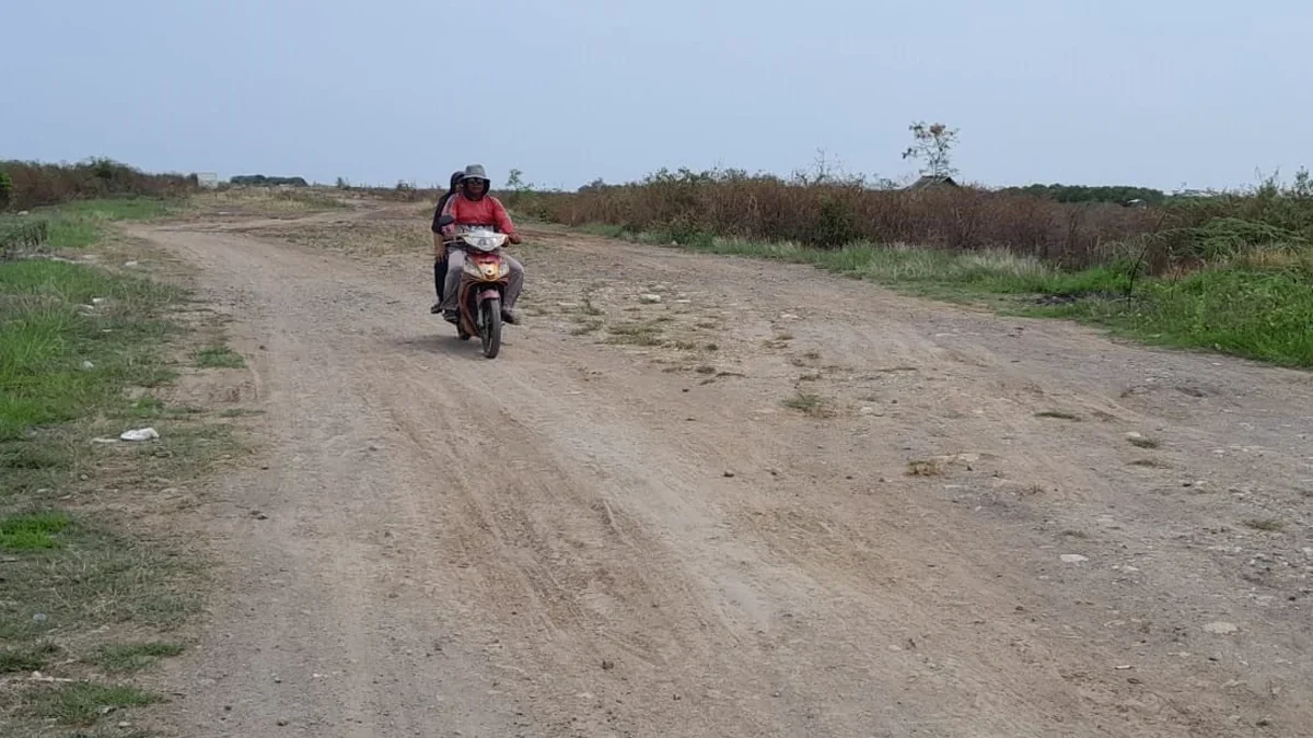 Pengendara sepeda motor melewati Jalan Lingkar Gebang yang masih belum tertata, belum lama ini.