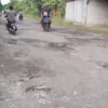 Pengendara sepeda motor menghindari jalan berlubang di Blok Kalijaga Mundu Pesisir.