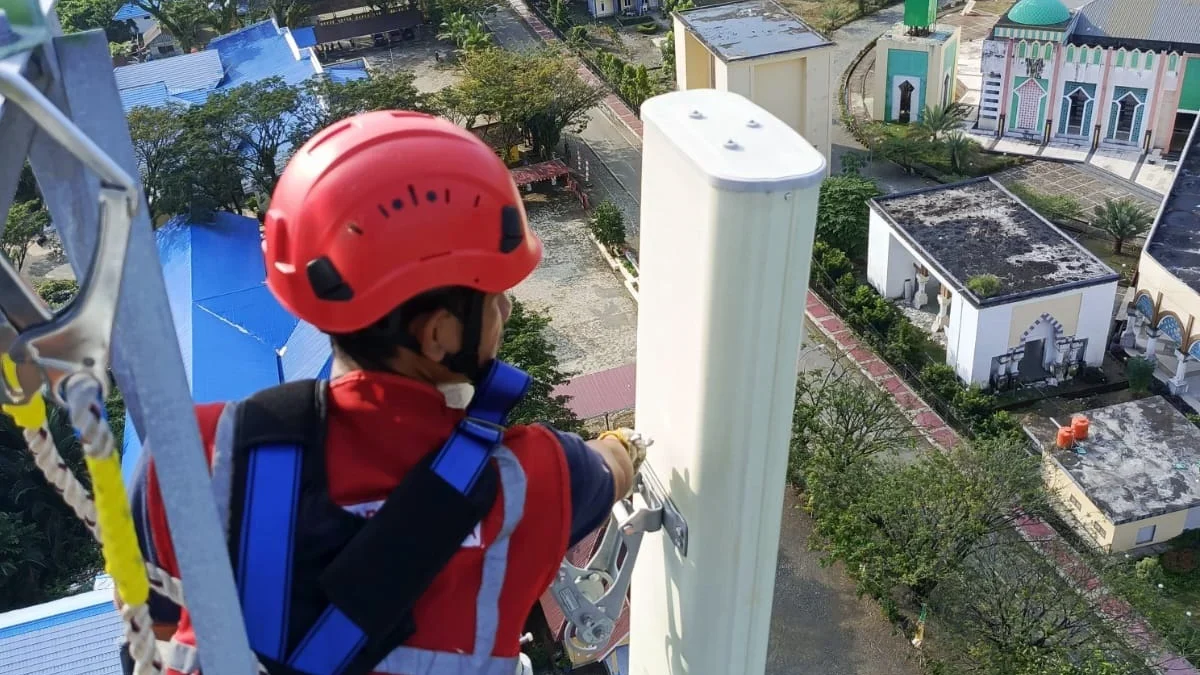 Teknisi XL Axiata sedang melakukan pemeliharaan perangkat BTS (Base Transceiver Station) di sebuah tower di De