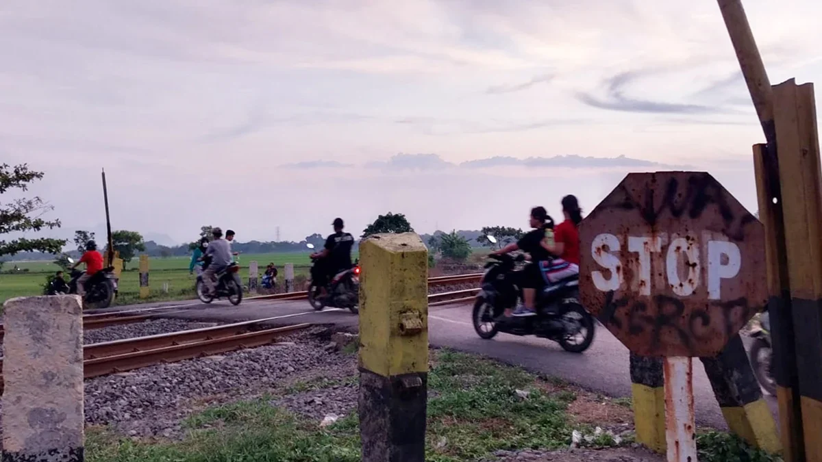 Tampak pengendara sepeda motor melintasi perlintasan sebidang di Desa Danamulya Kecamatan Plumbon.