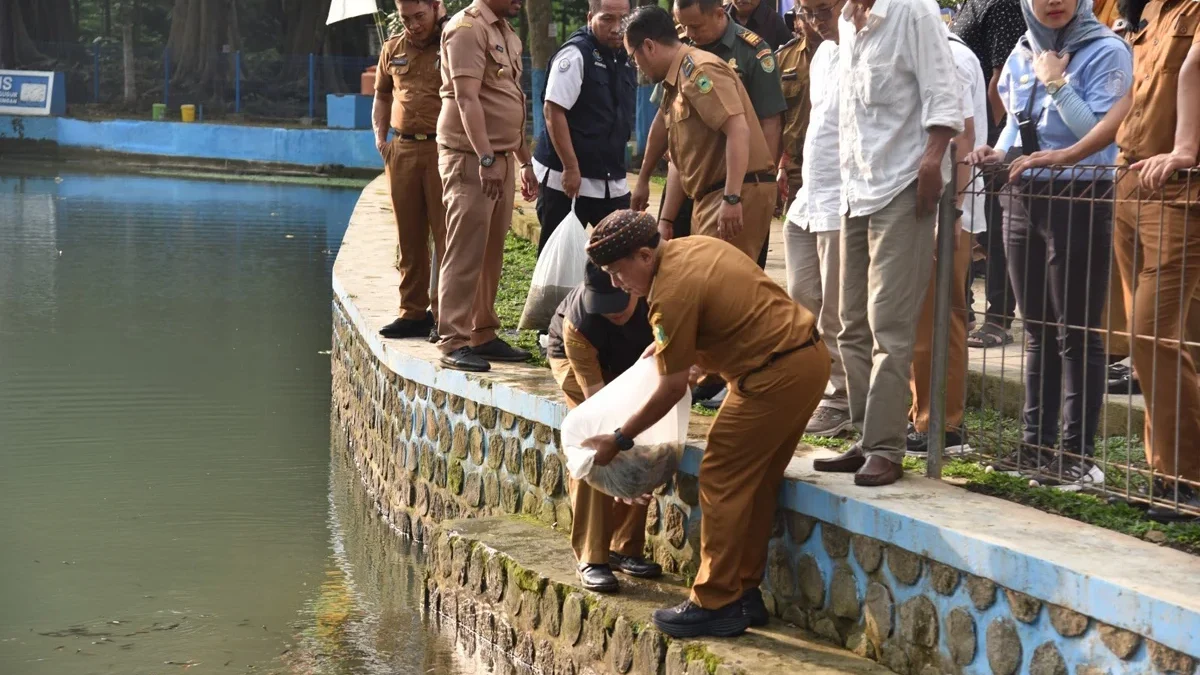 Sekda Kabupaten Kuningan Dr H Dian Rachmat Yanuar MSi melepas benih ikan di Situ Citiis, Dusun Manis, Desa Cil