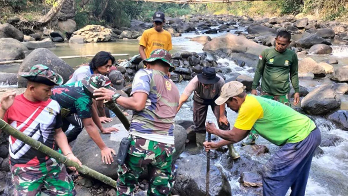 Anggota Kodim 0620 Kabupaten Cirebon gotong royong dengan warga melaksanakan pembangunan pipanisasi