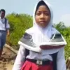 pelajar lintasi jalan rusak tanpa alas kaki