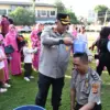 menyiramkan air kembang kepada personel