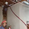 Petugas Damkar Indramayu sedang memadamkan api yang masih menyala di bagian plafon rumah Hj Tarinih
